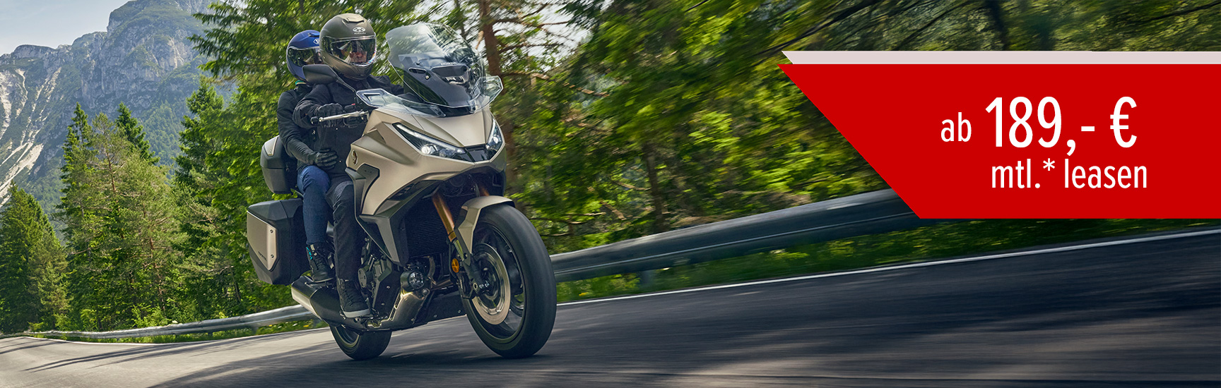 Ein Mann fährt auf einer Honda NT1100 drurch die Berge.