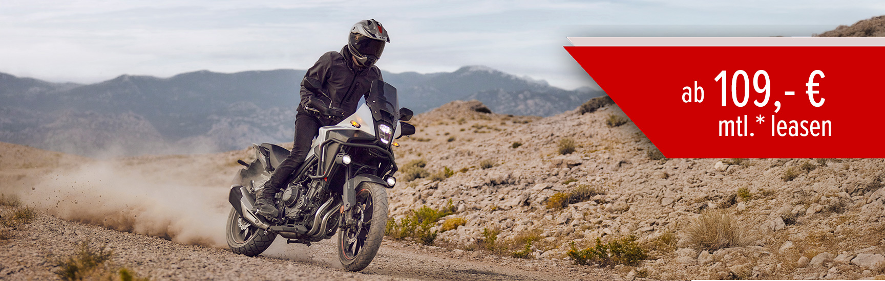 Ein Mann fährt auf einer Honda NX500 durch Offroad Gelände.